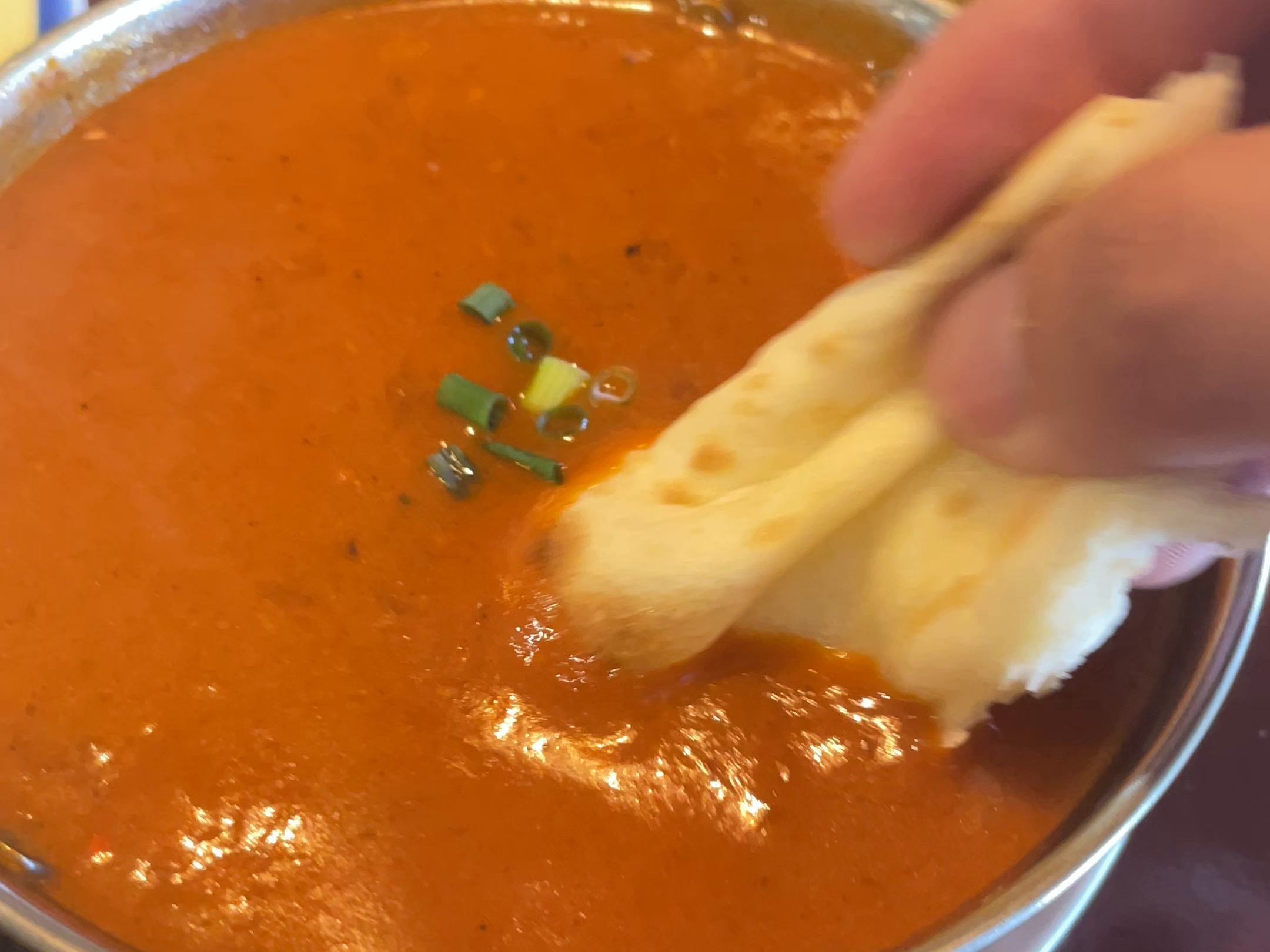 ナンをカレーにつける手元