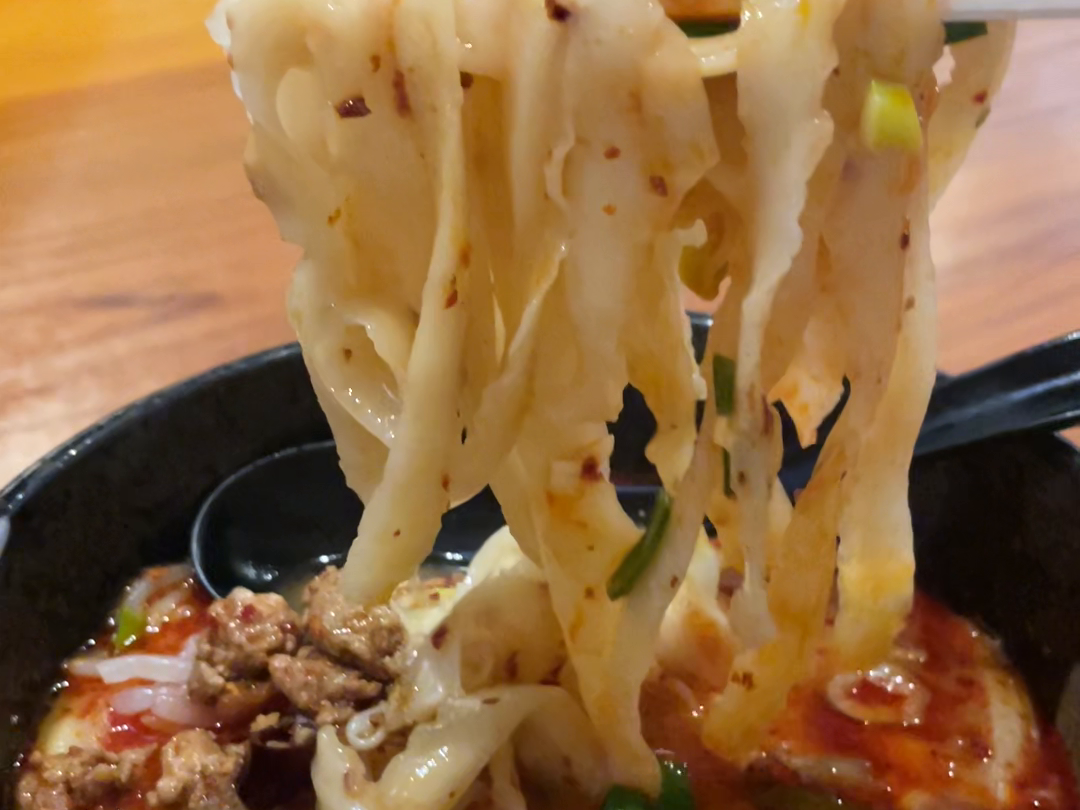 刀削麺を箸で持ち上げる