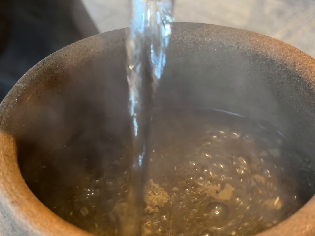 薬草の入った壺に湯を注ぐ場面
